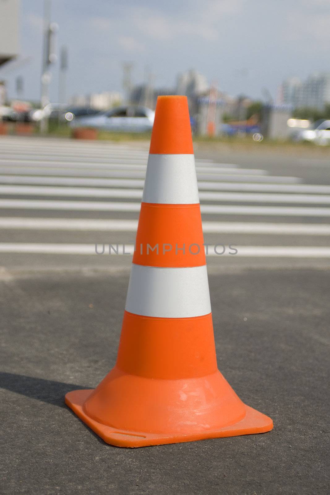 Close up of one traffic cone on a road with path