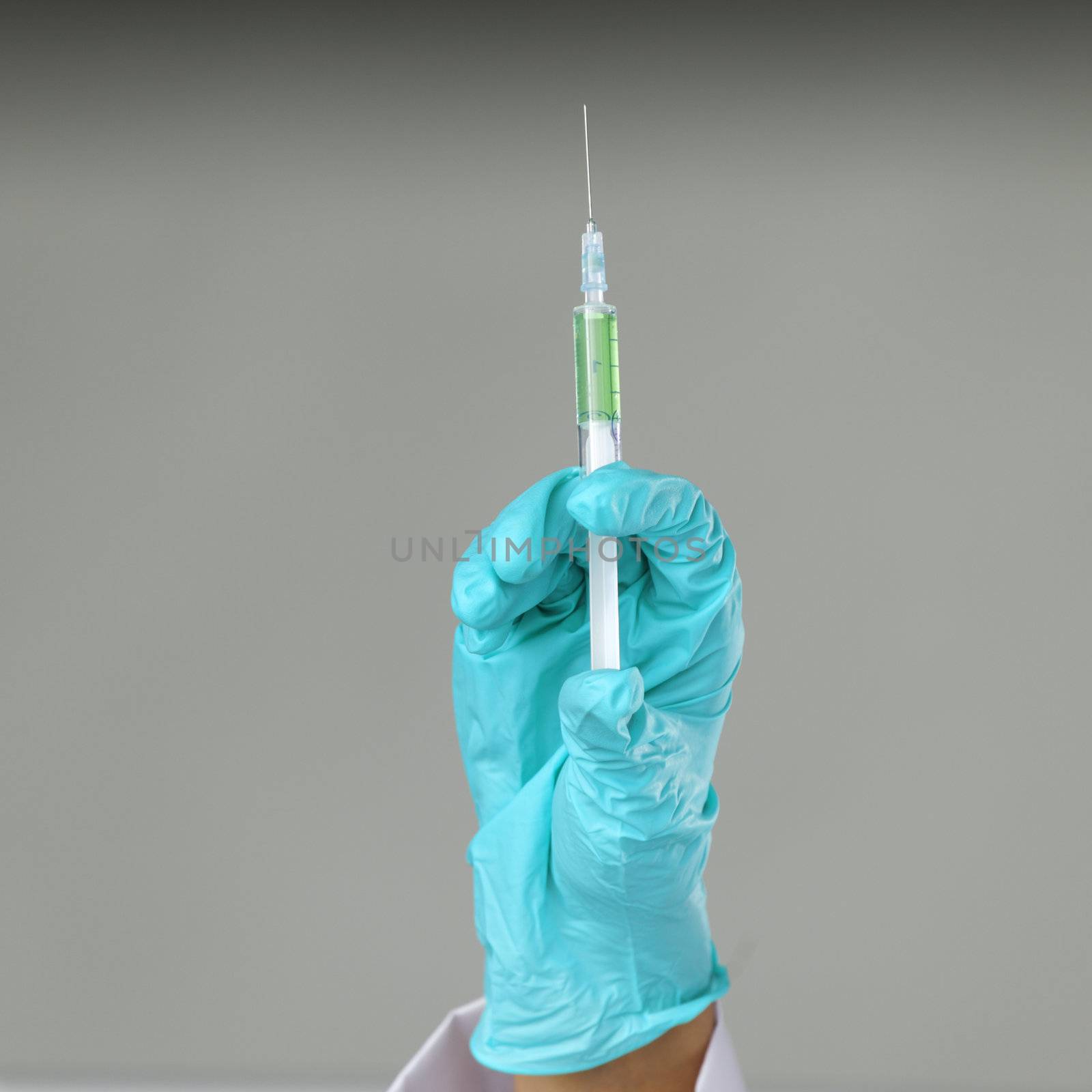 syringe in hand on gray background