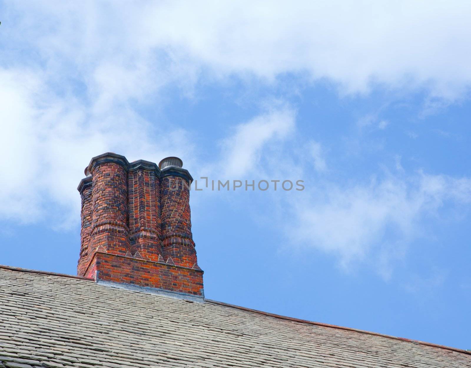 Fancy old english design round chimney stacks against blue sky