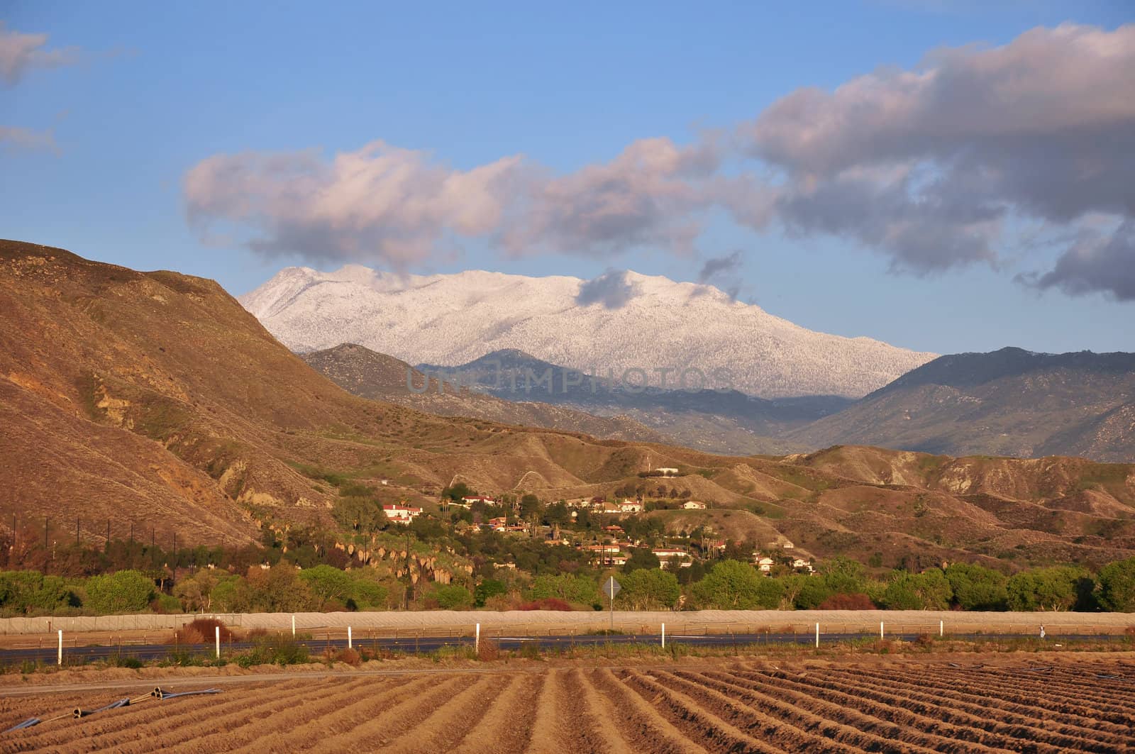 View of Southern California's snow-capped Mount San Jacinto with recently plowed farmland in the foreground.