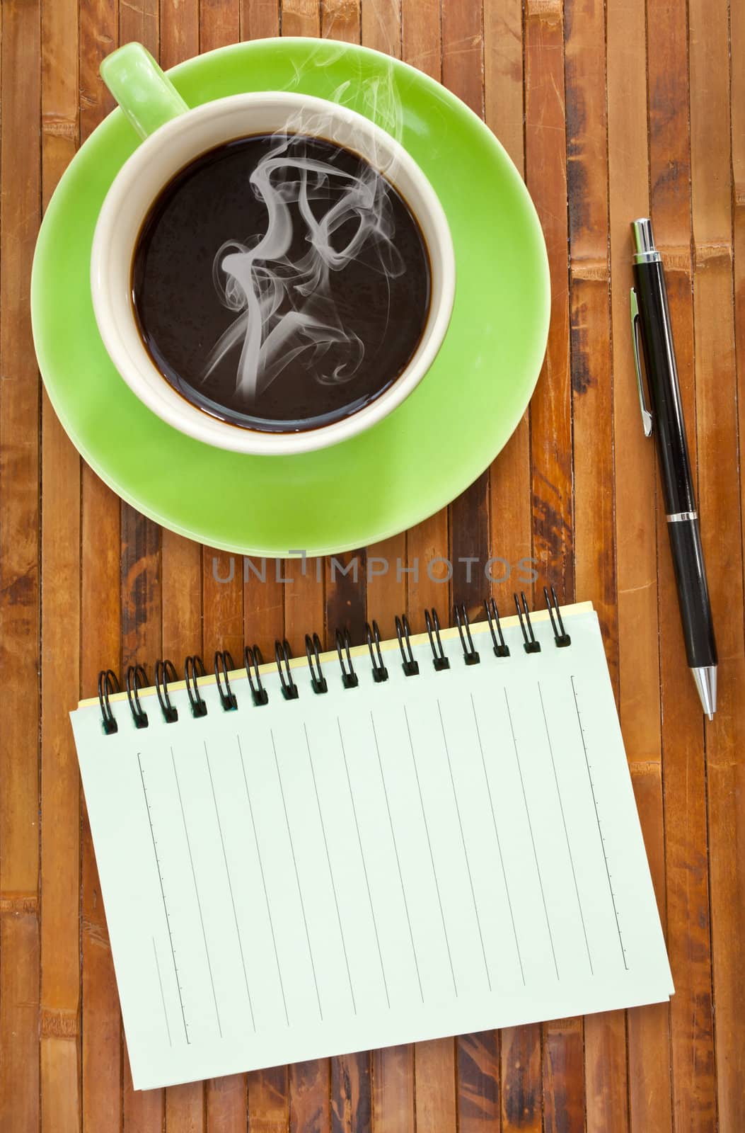 green cup of hot coffee and note paper on wood background