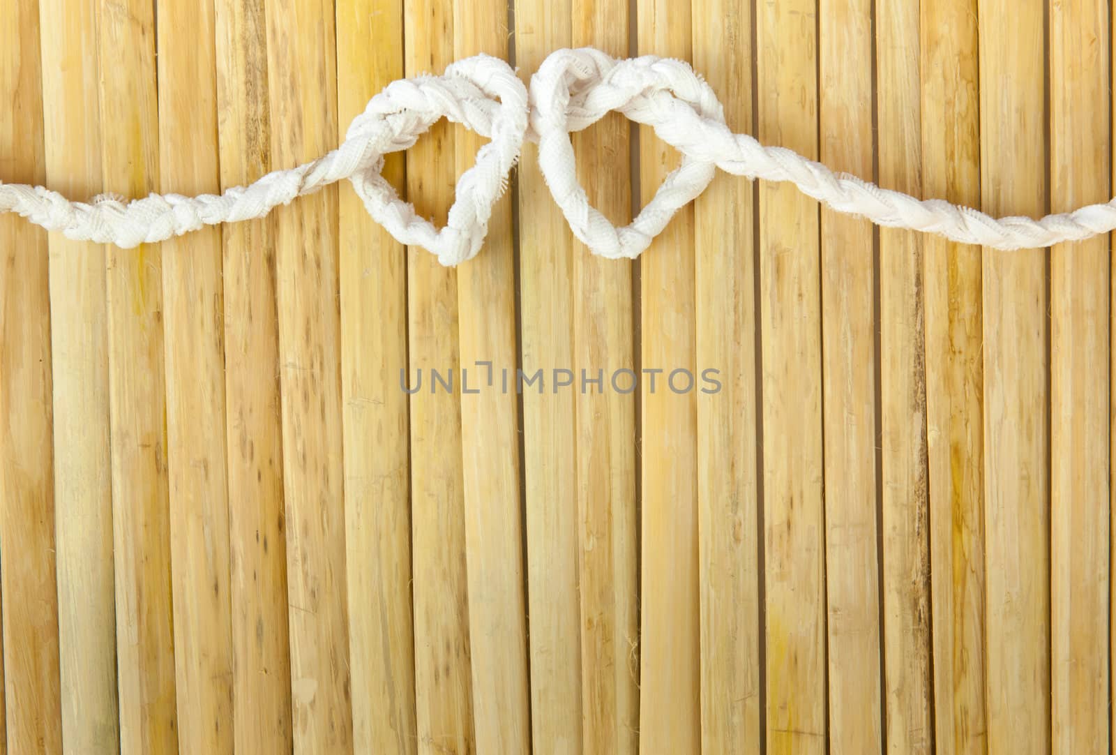 Rope in the shape of heart isolated on wood background