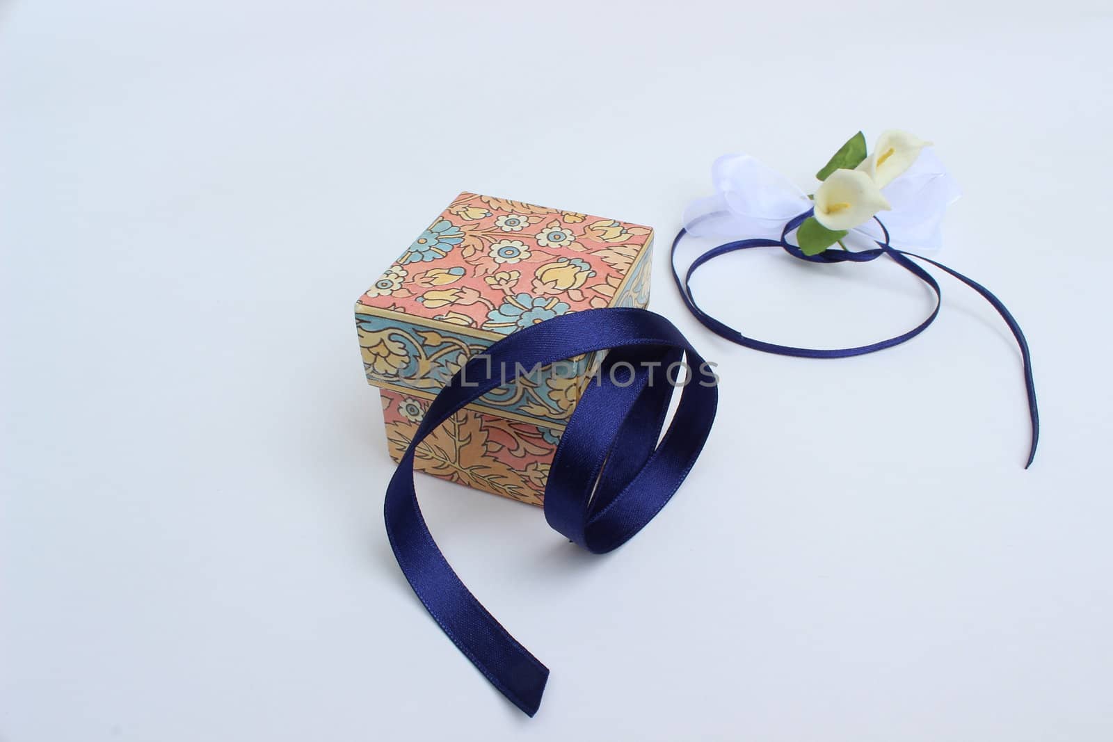 image of closed gift box with blue ribbon and decorative flowers