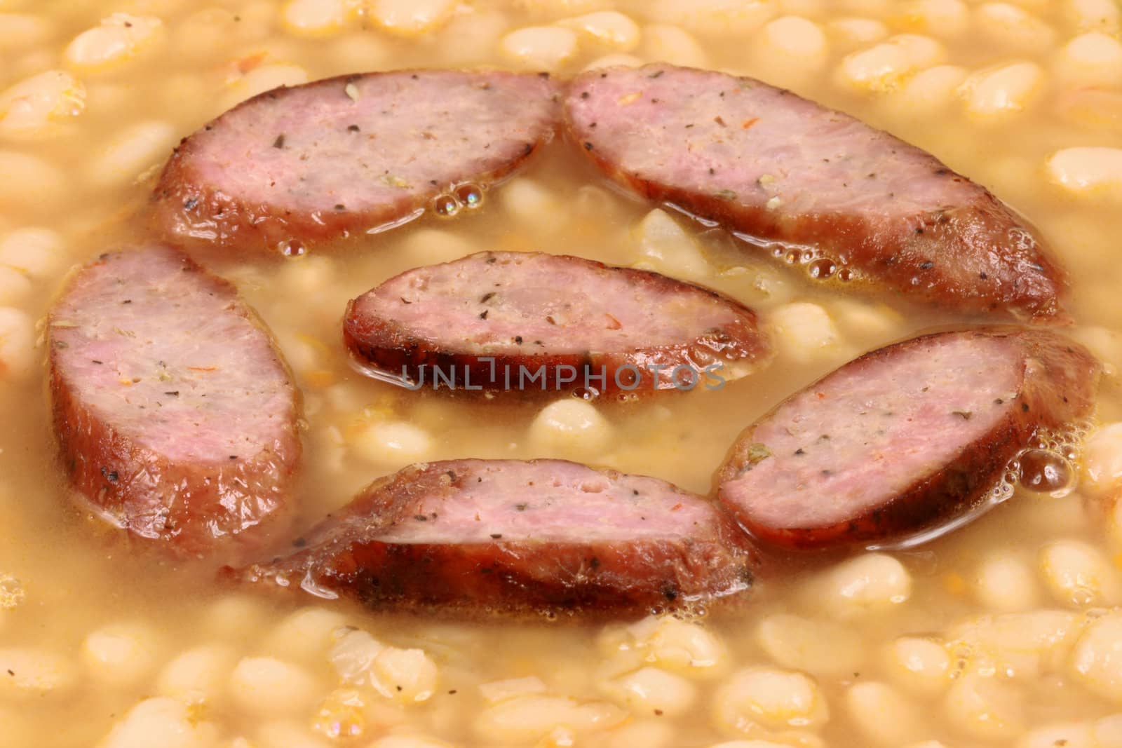white beans with sausage close up by tacar