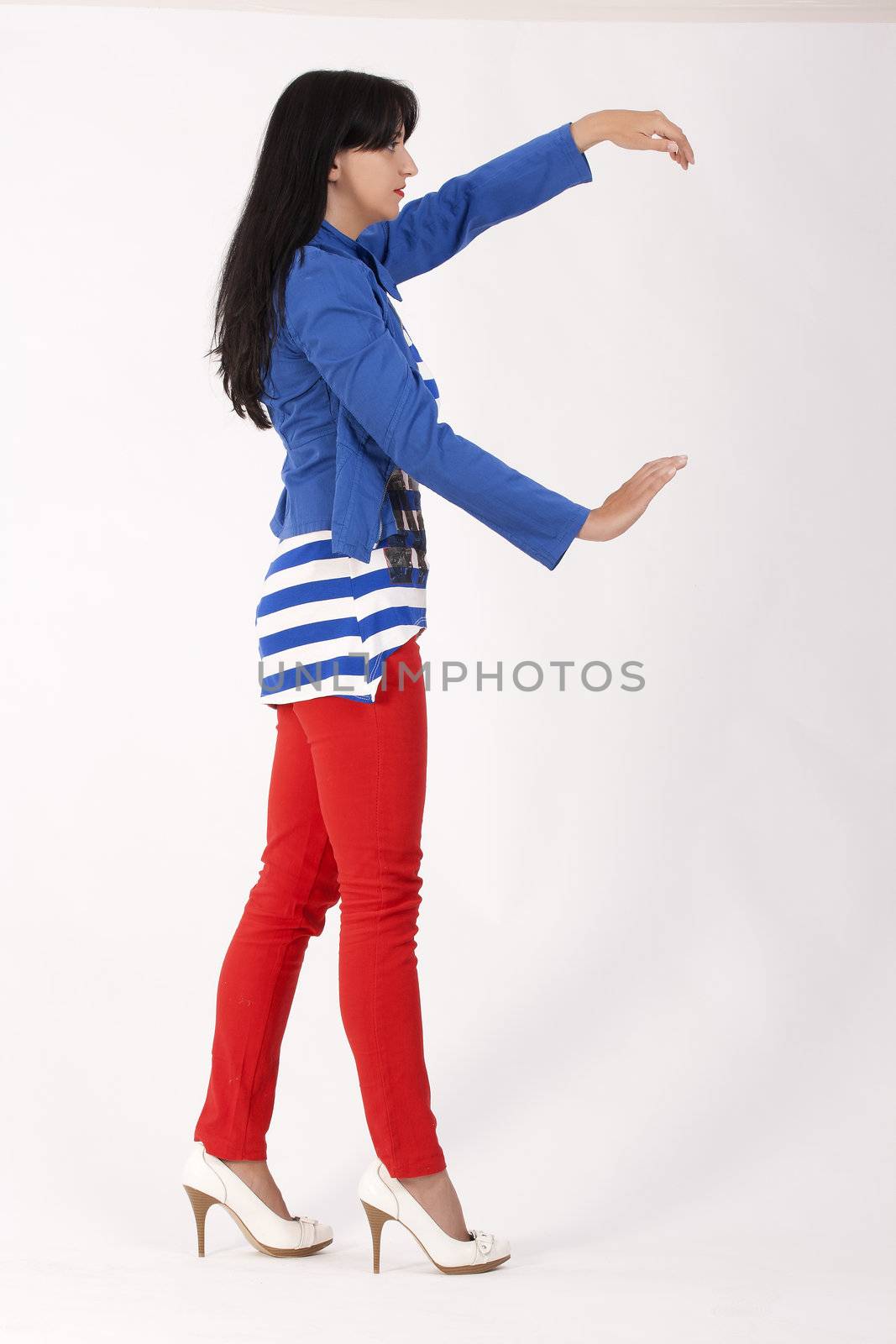 Model posing with red pants, striped shirt and blue jacket