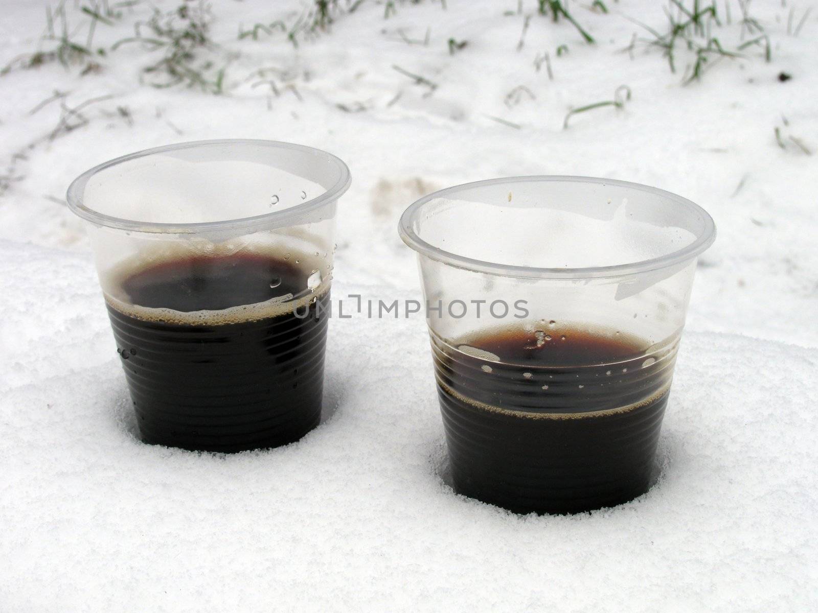 two cups of hot coffee in a snow
