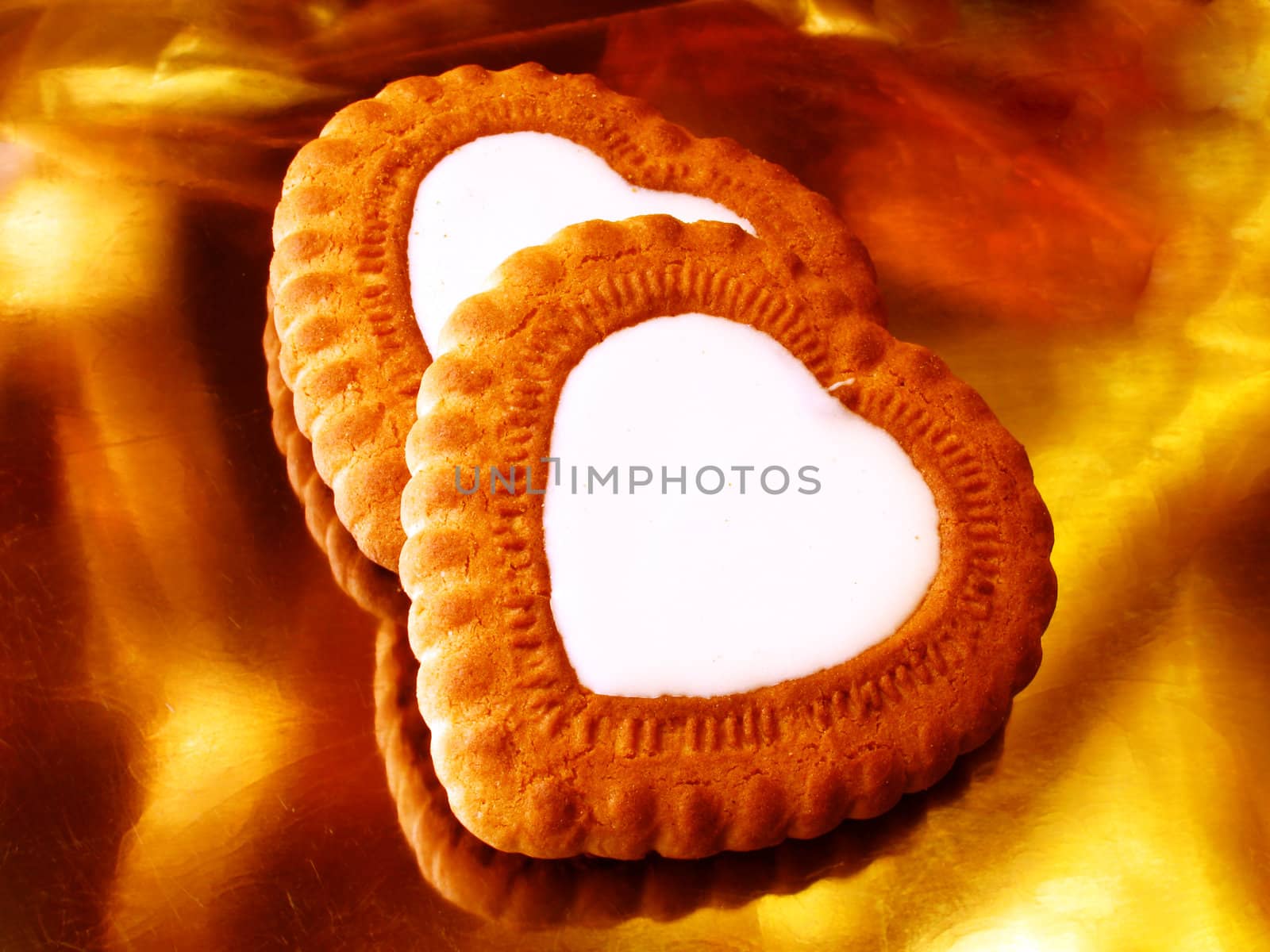 two heart-shaped biscuits over golden background