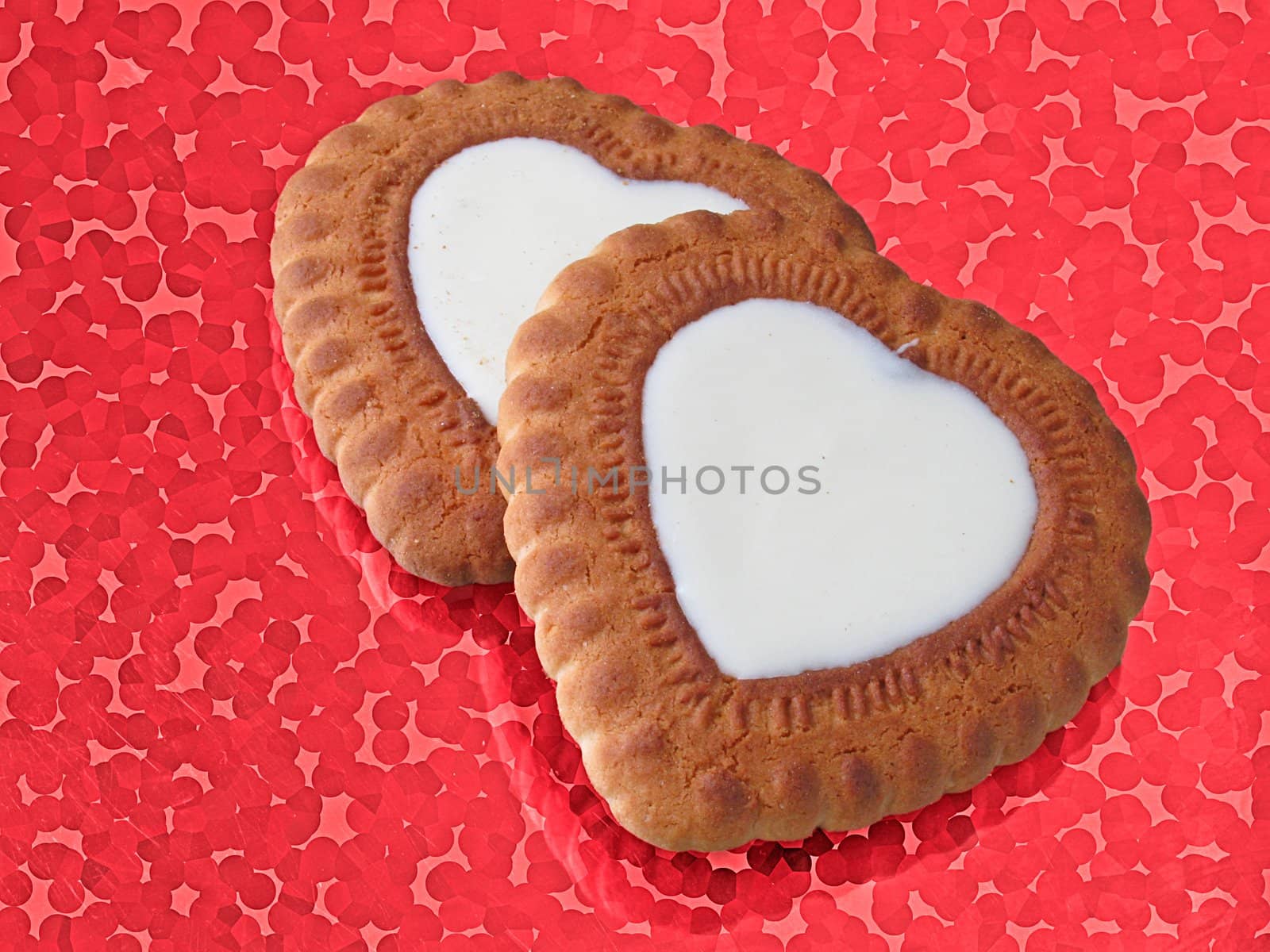 two heart-shaped biscuits over red abstract background