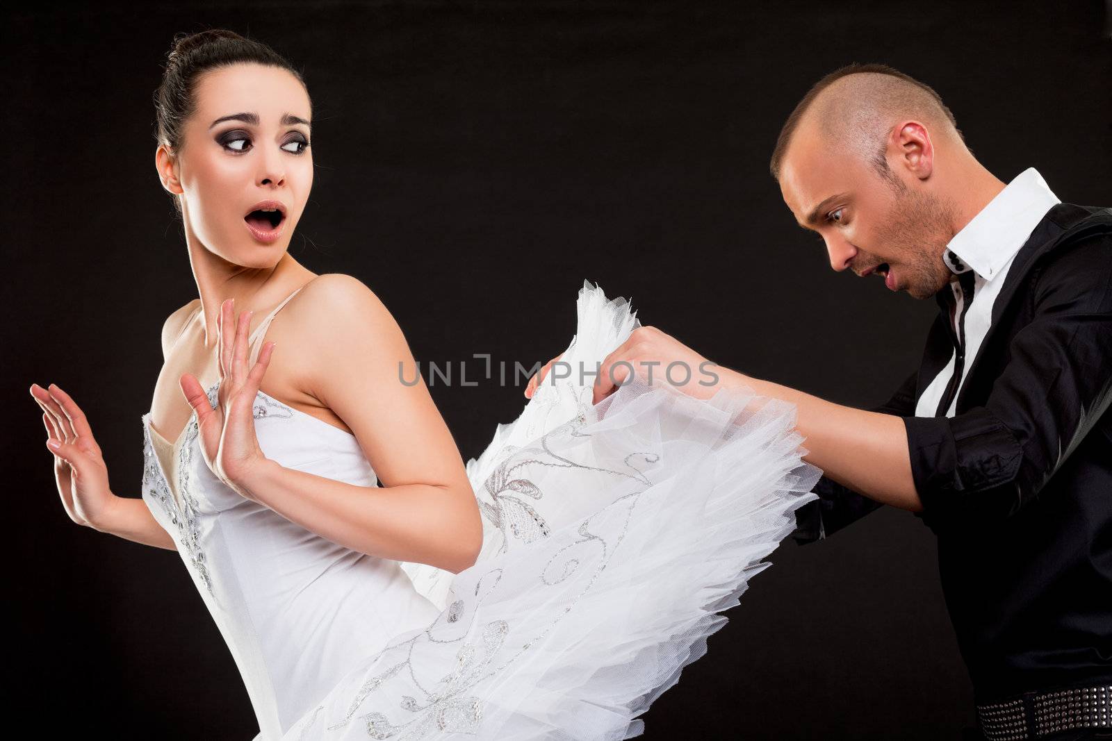 Man looking under beautiful ballerina pettiskirt, both looking surprised