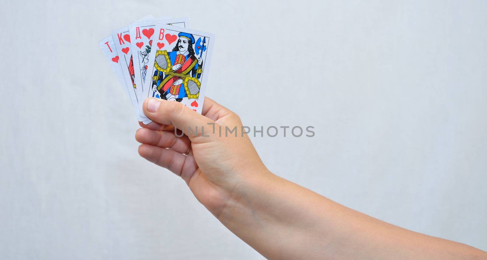 On white background, the photo of the hand with playing cards.