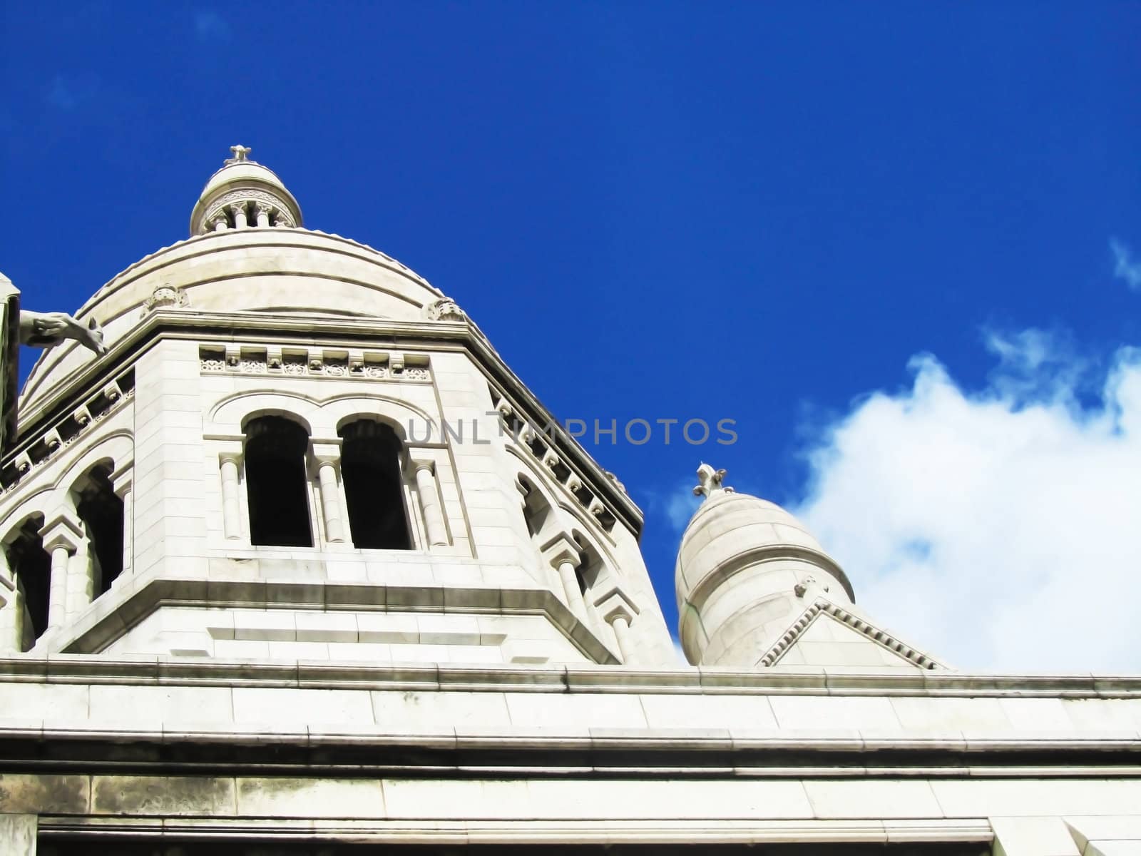 White church on a blue sky with domes and gargoyles