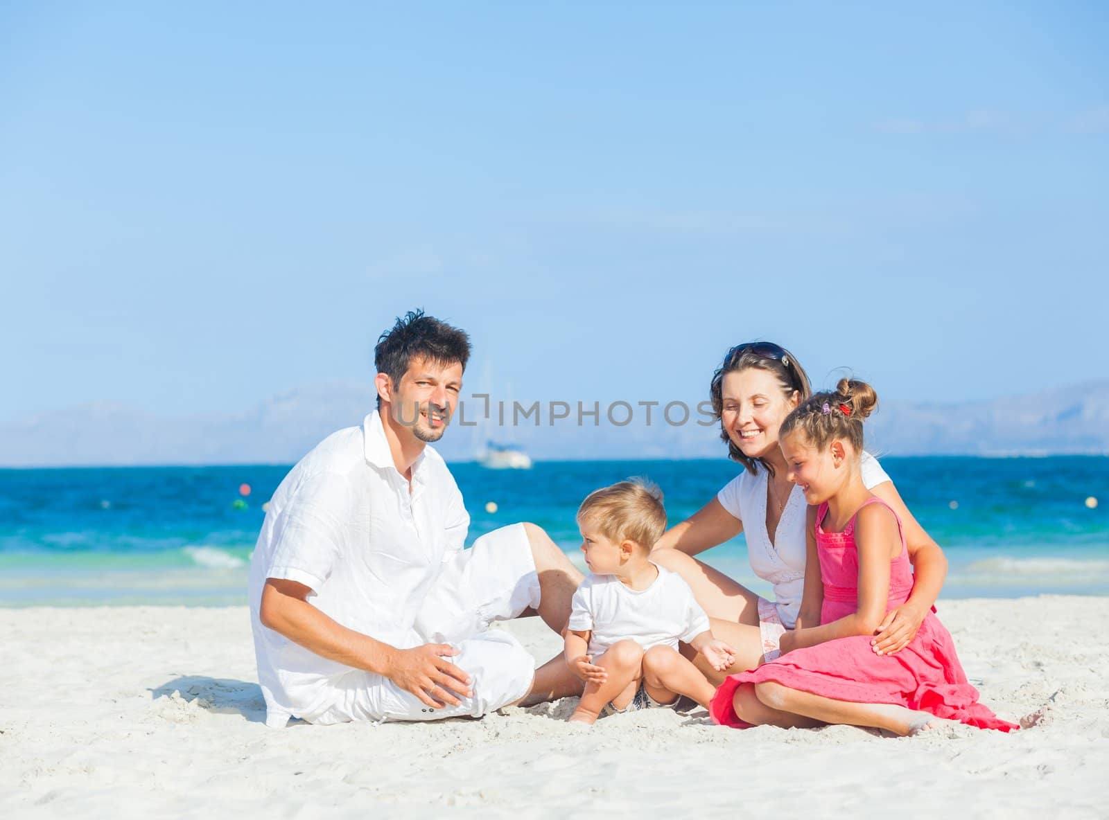 Family of four having fun on tropical beach