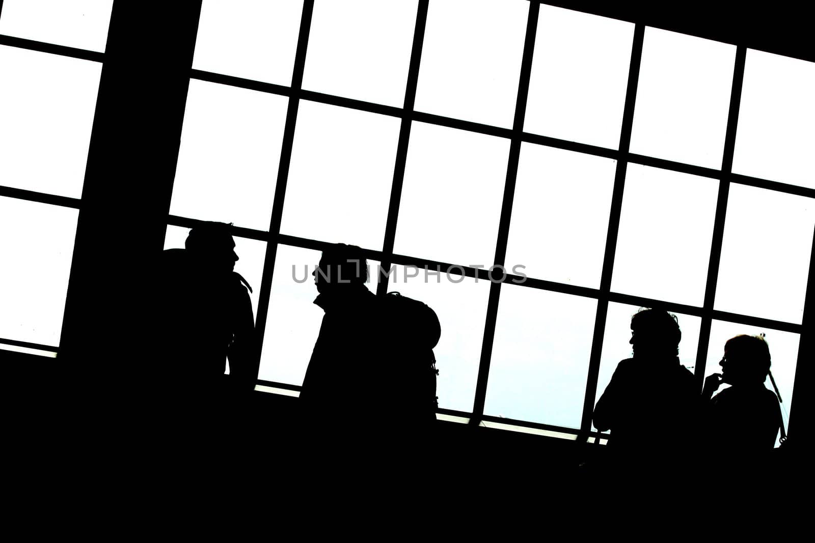 people silhouettes on a big window