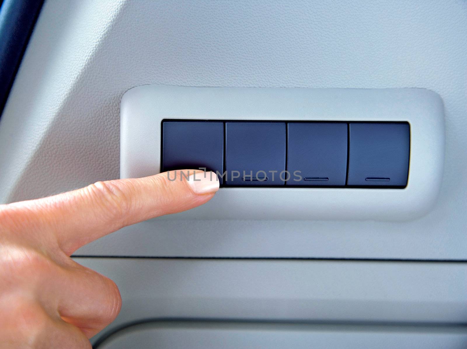 finger on buttons of device in a car