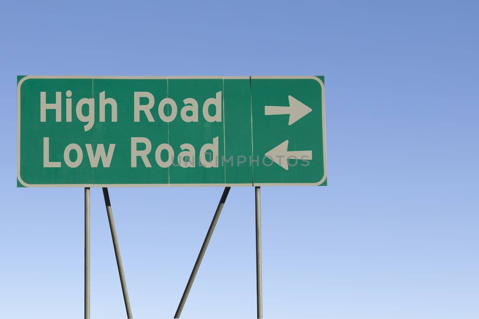 Green road sign with a blue sky gradient background.