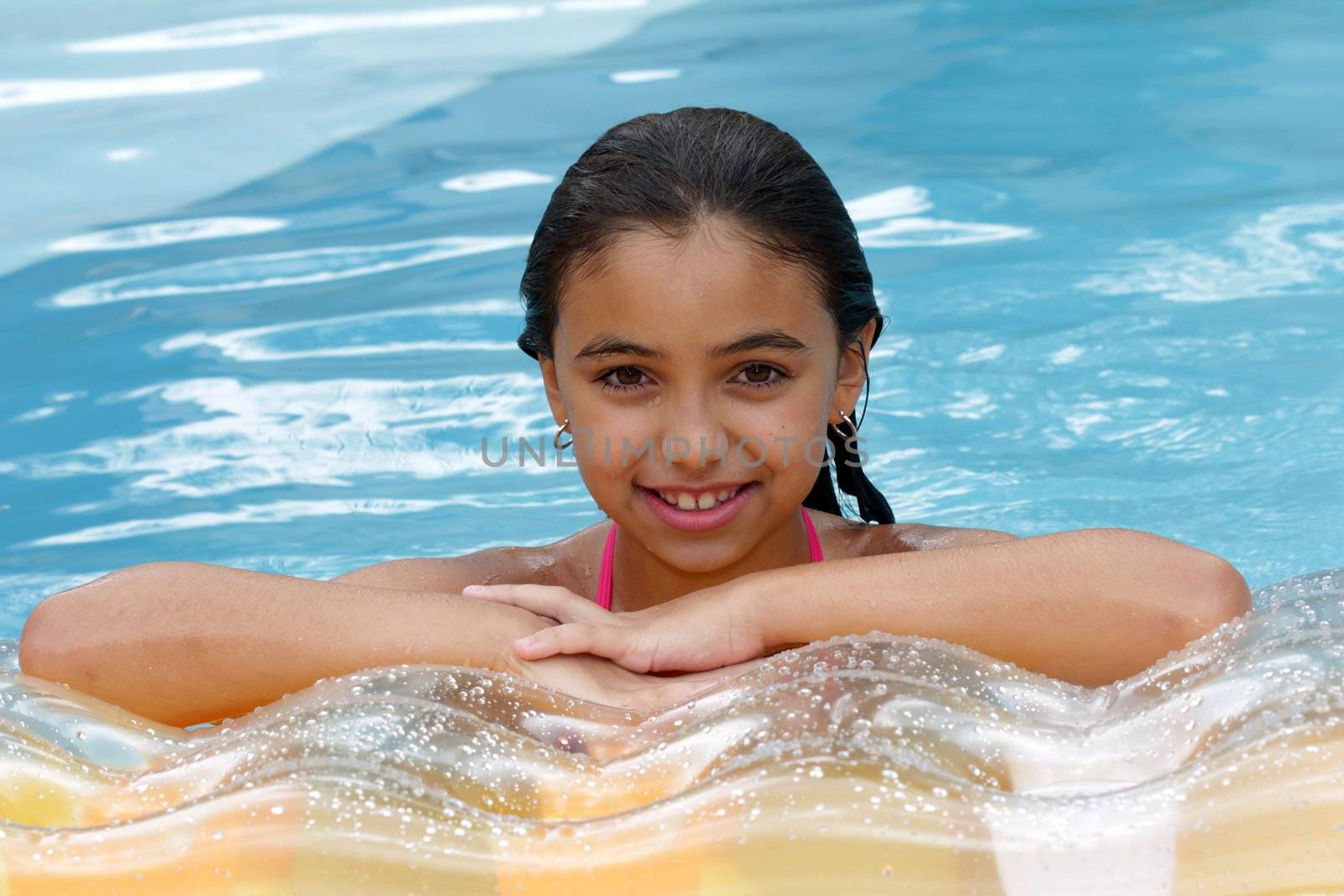 Young girl swimming on blue swimming pool