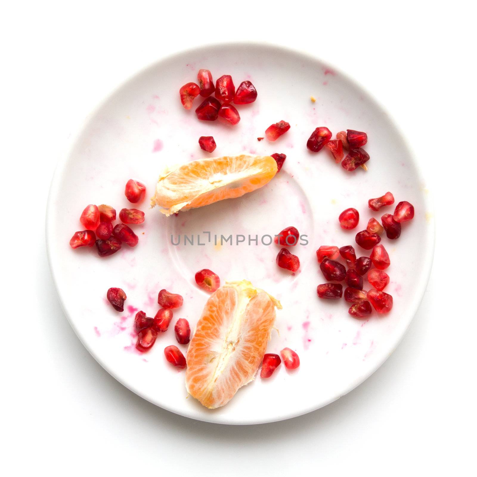 Pomegranate with an orange on a plate on a white background by schankz