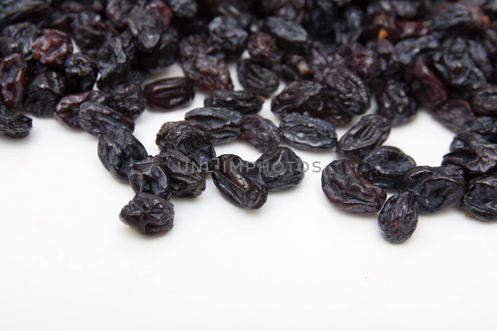 black raisins on a white background by schankz
