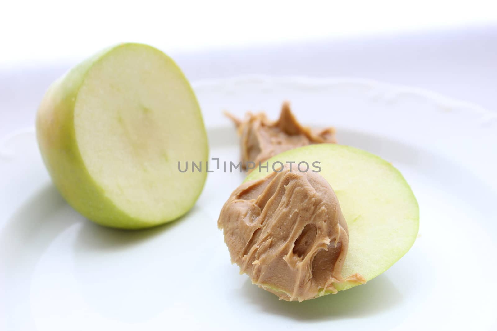 Sliced off green apple with peanut butter.