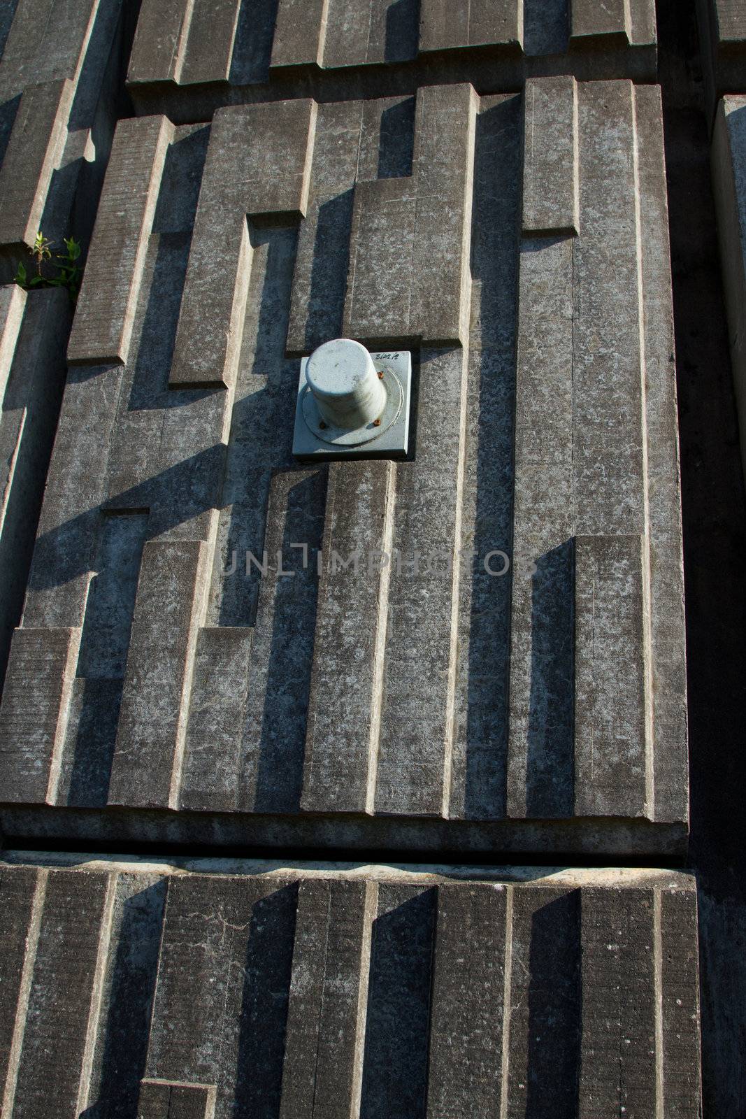 A section of an engineered precast retaining wall with a metal pin casing.