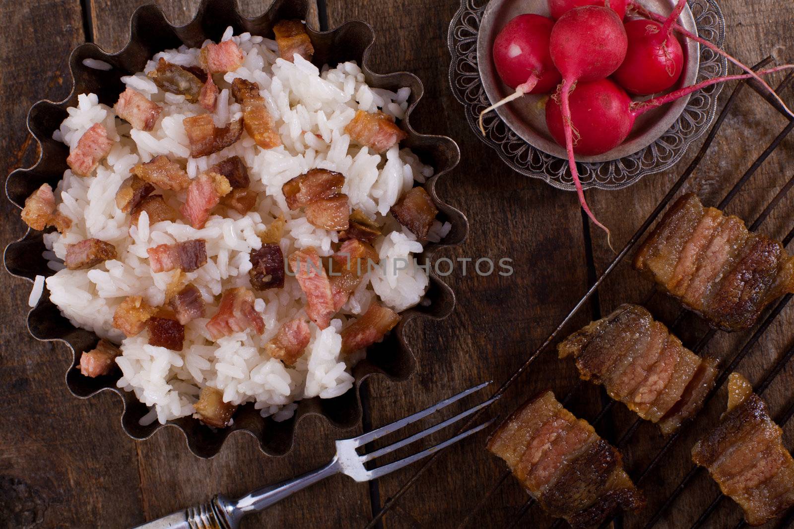Boiled rice with fried  meat  on the wooden table