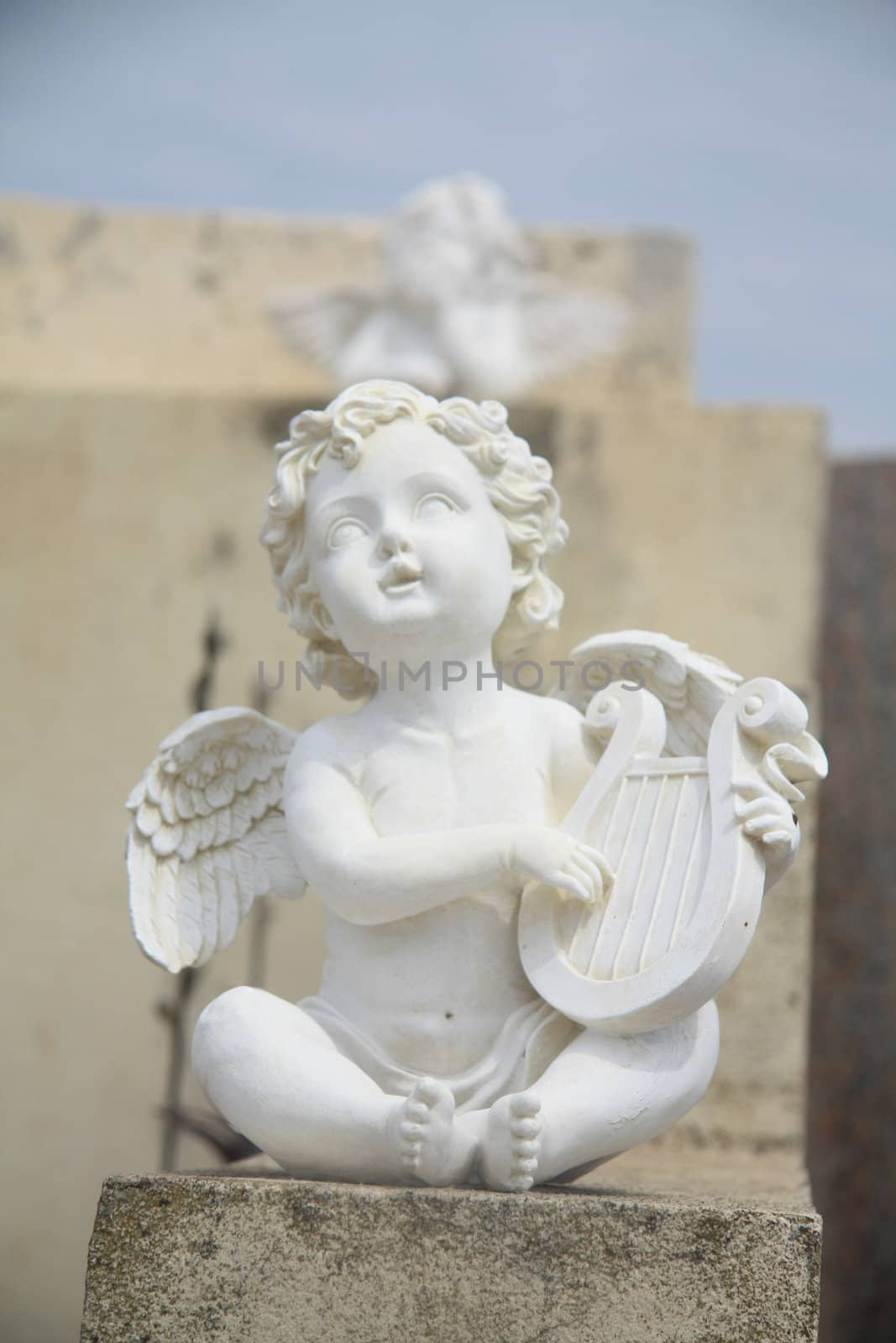 Guarding angel playing the harp on a cemetery in the Provence, France