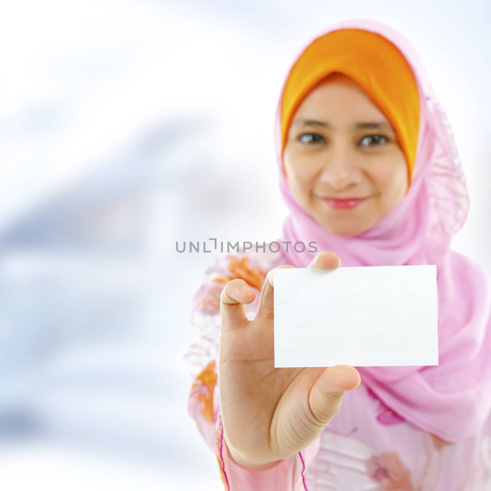 Muslim female holding business card, focus on hand