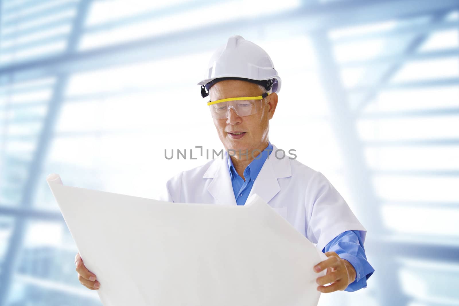 Senior Asian engineer with blueprints office background