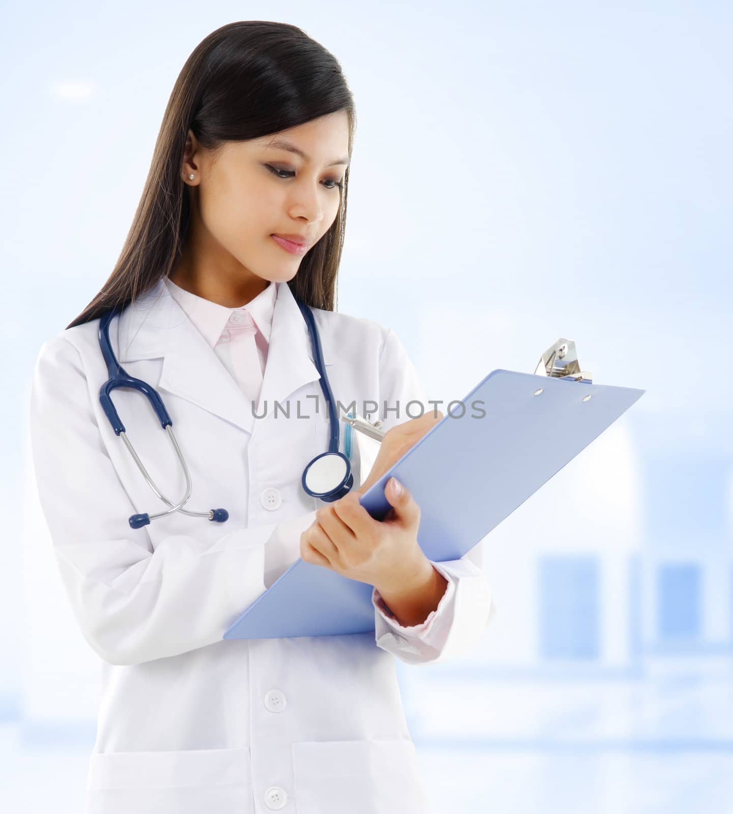 Young Asian female doctor writing medical report