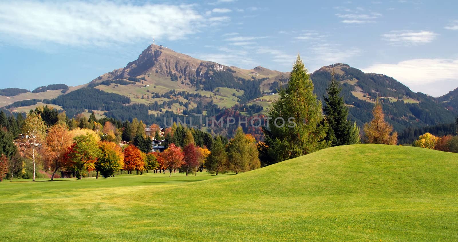Panoramic view of grassland and green mountains on a sunny day at Kitzbuhel - Austria