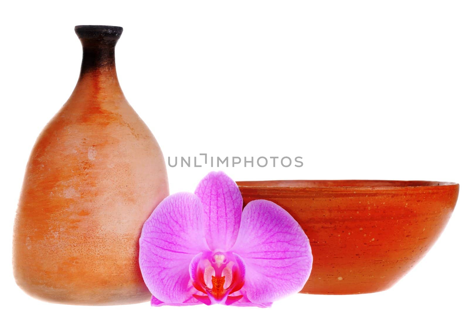 Old-fashioned clay jag and dish with orchid flower isolated on white background