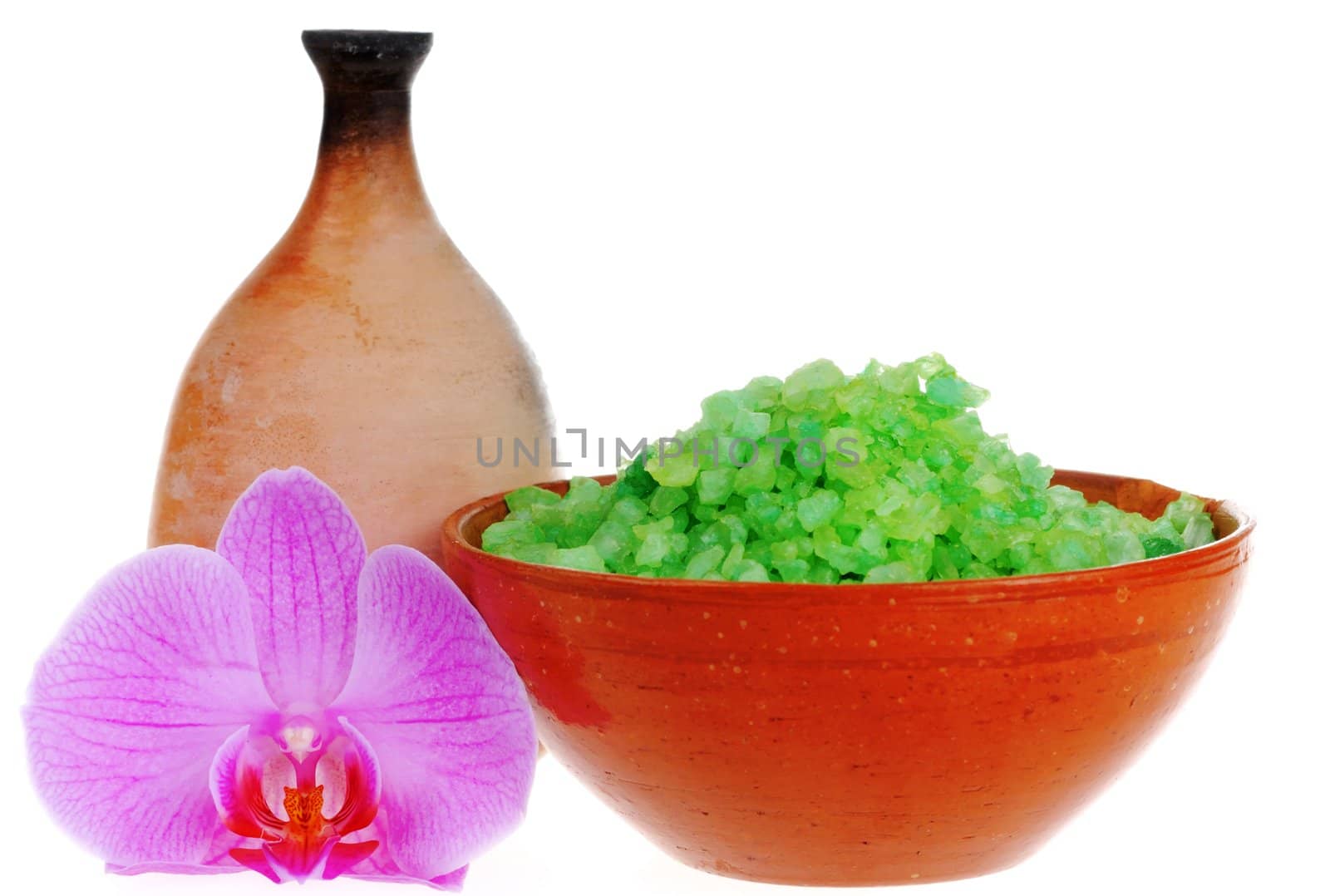 Old-fashioned dish with salt for bath, orchid flower and jug on white background. Focus on the flower.