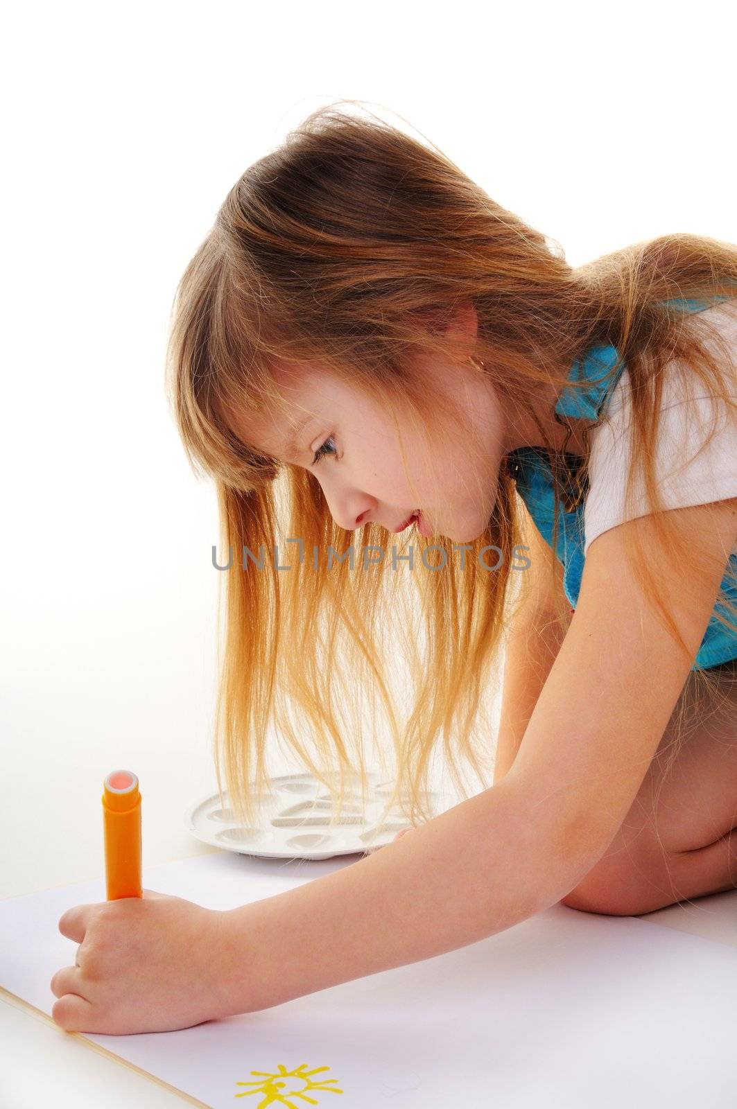 Nice girl with blonde long hair is painting on white background