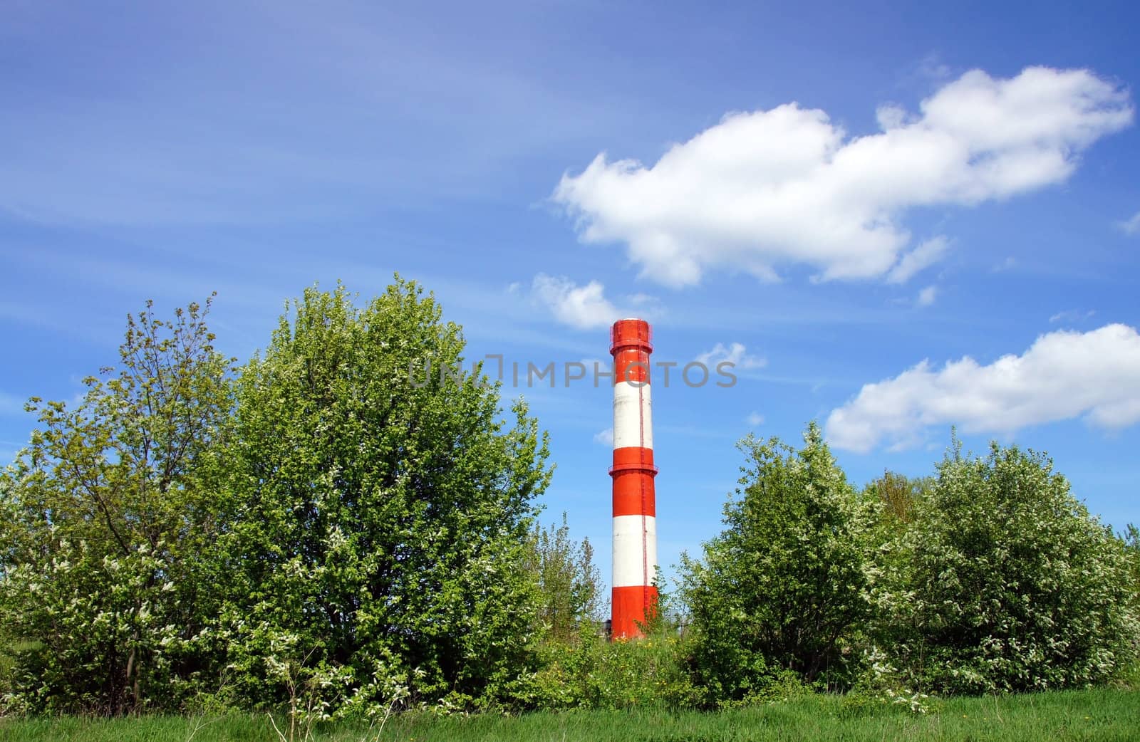 Pipe and the sky on a background of green trees