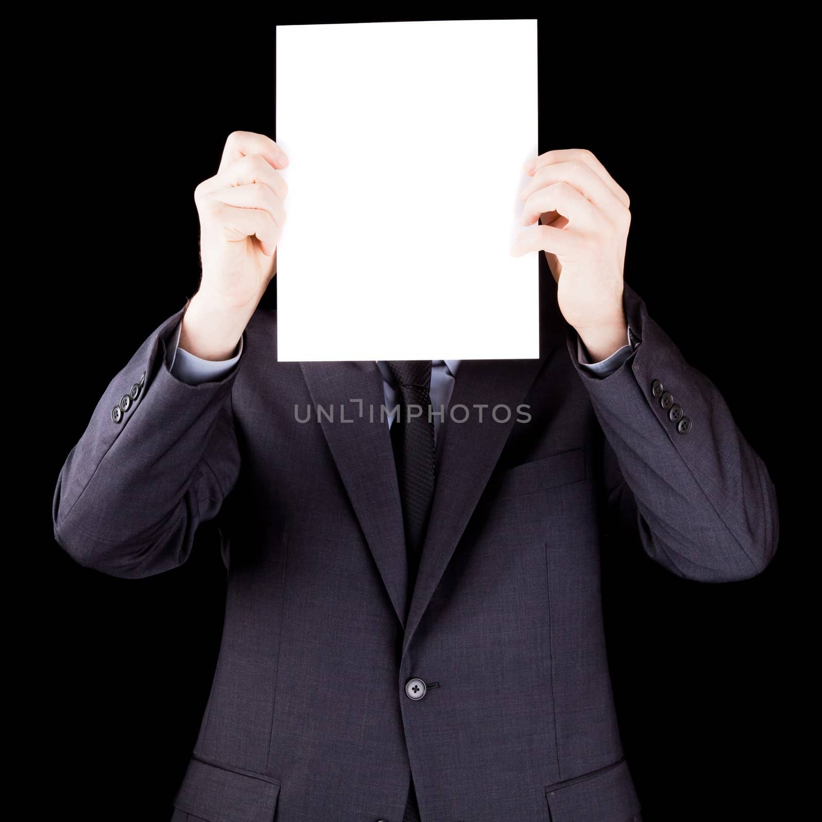 Businessman holding  a sheet of paper in front of his face by aetb