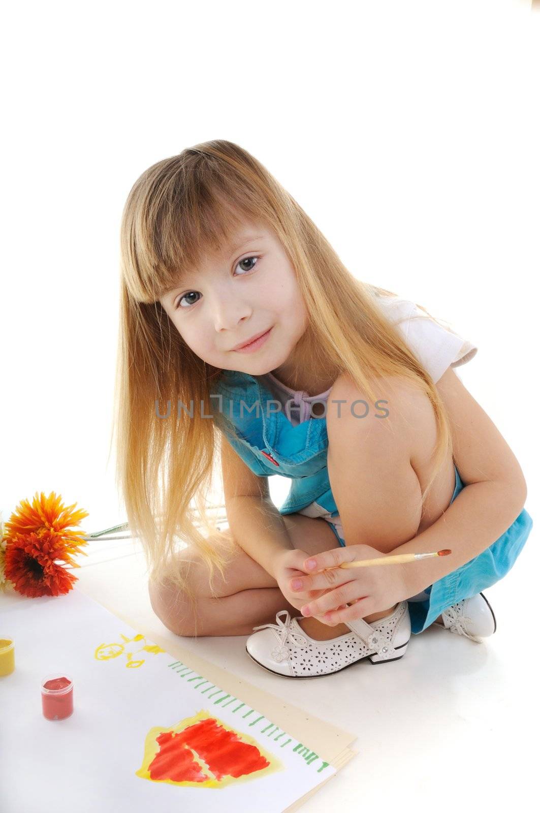 Nice girl with blonde long hair is painting on white background