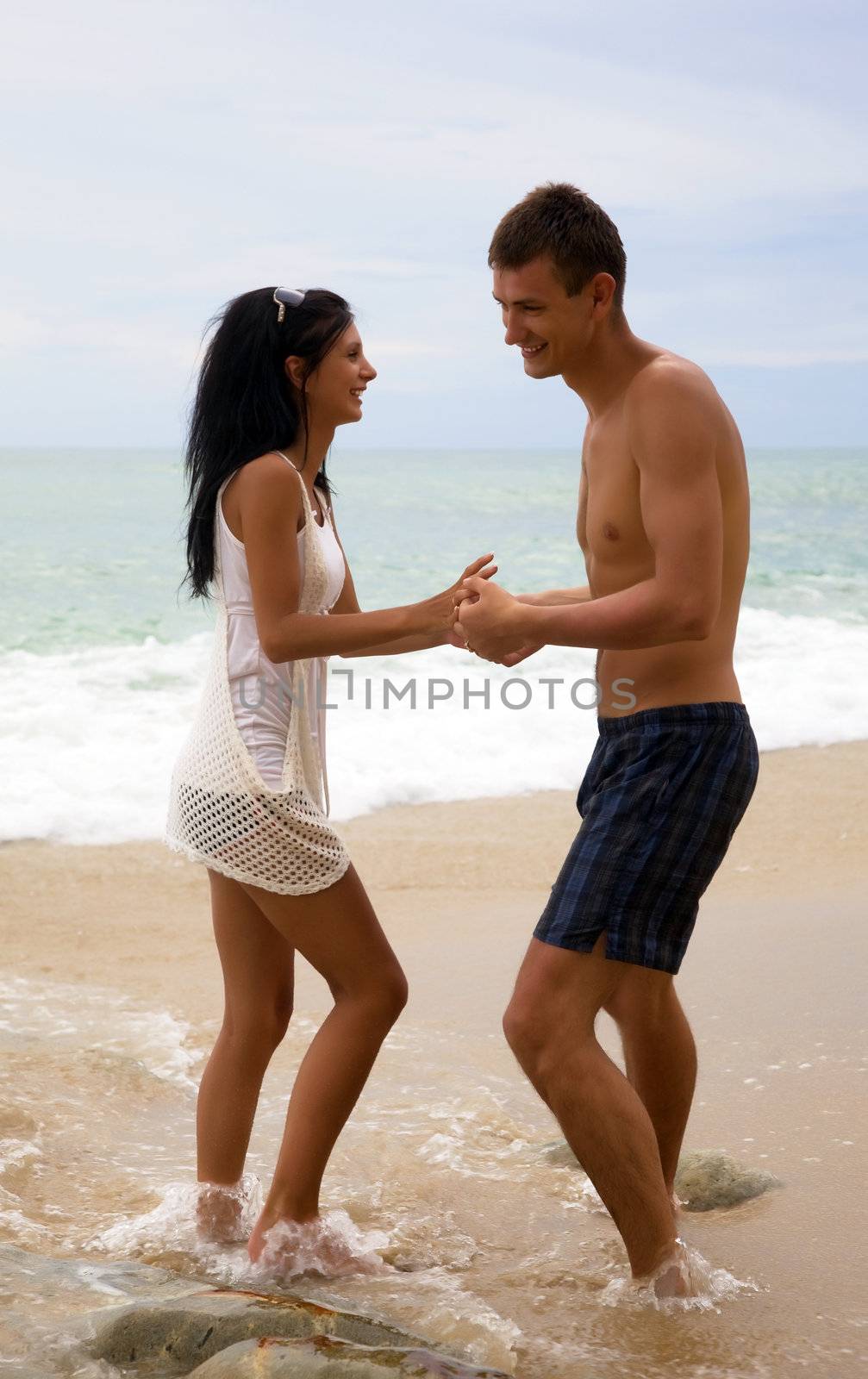 A man and woman enjoy life at the beach by AleksandrN