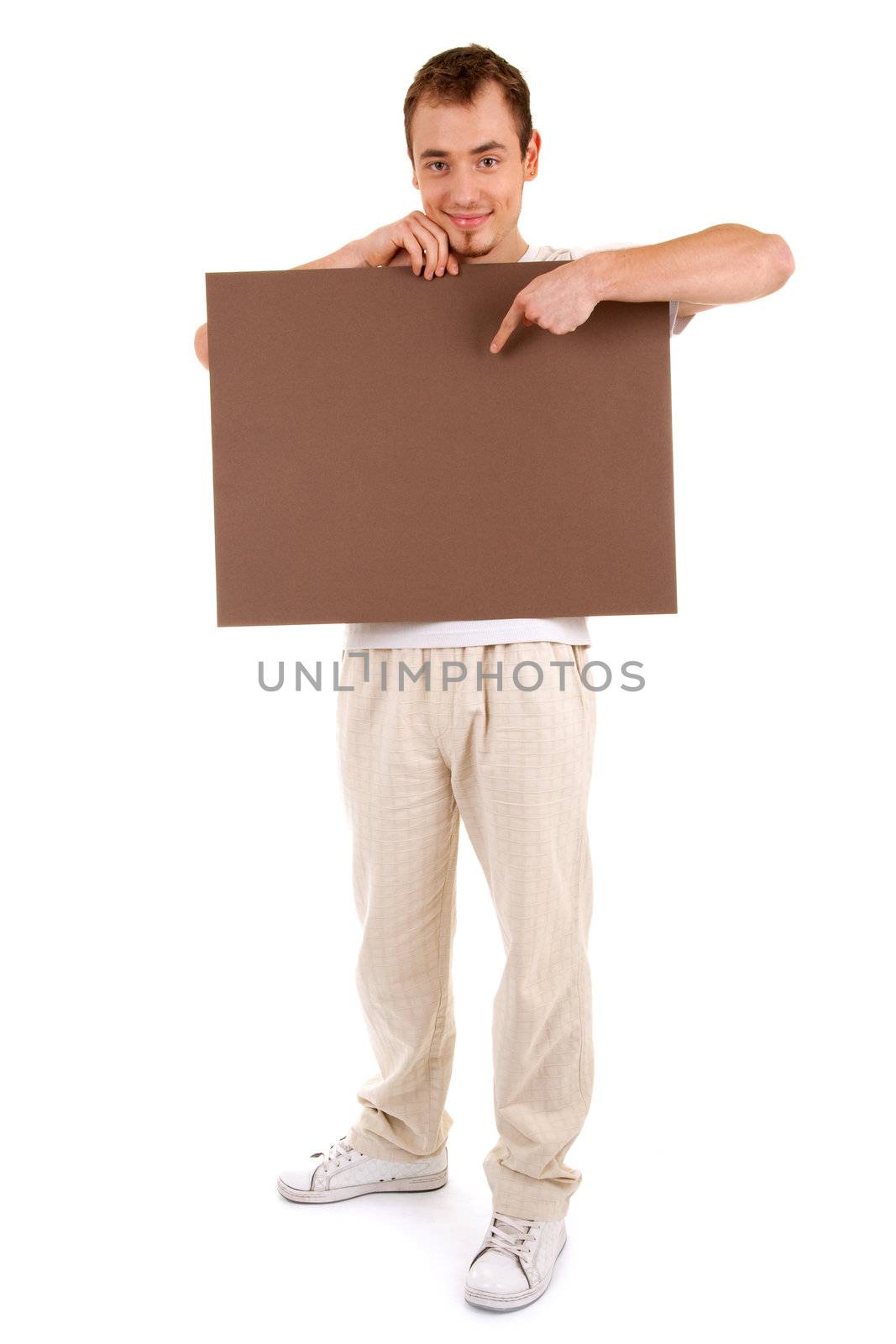 Young man in casual clothes shows by finger on a brown empty board for your text