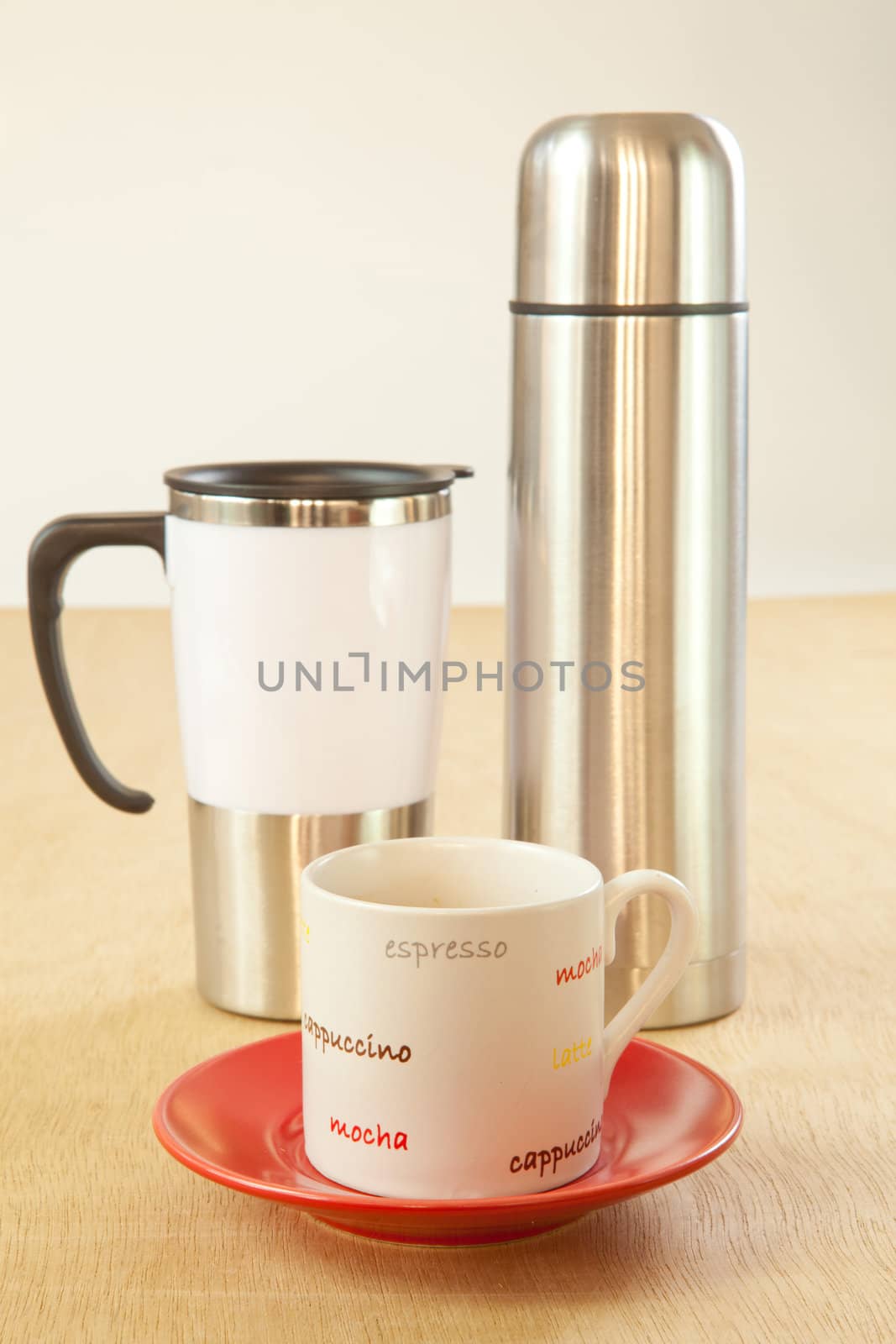 metal cup and water bottle on wood background