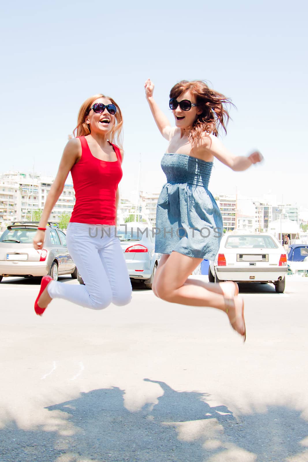 Photo of a young, beautiful and cheerful girls who jumps high sunny summer day