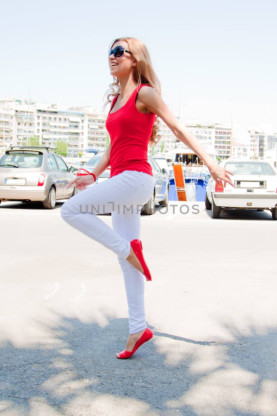 Photo of a young, beautiful and cheerful girl who jumps high sunny summer day