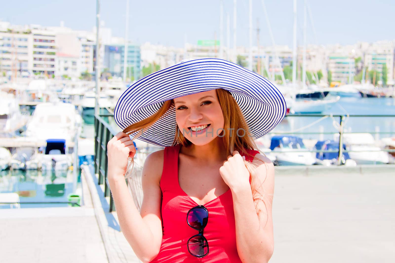 Photo of a young and beautiful girl walking down the street along the marina