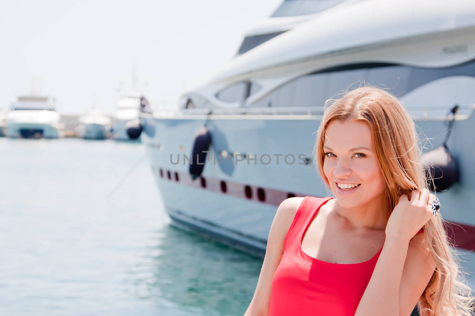 Photo of a young and beautiful girl against the backdrop of yachts in the port