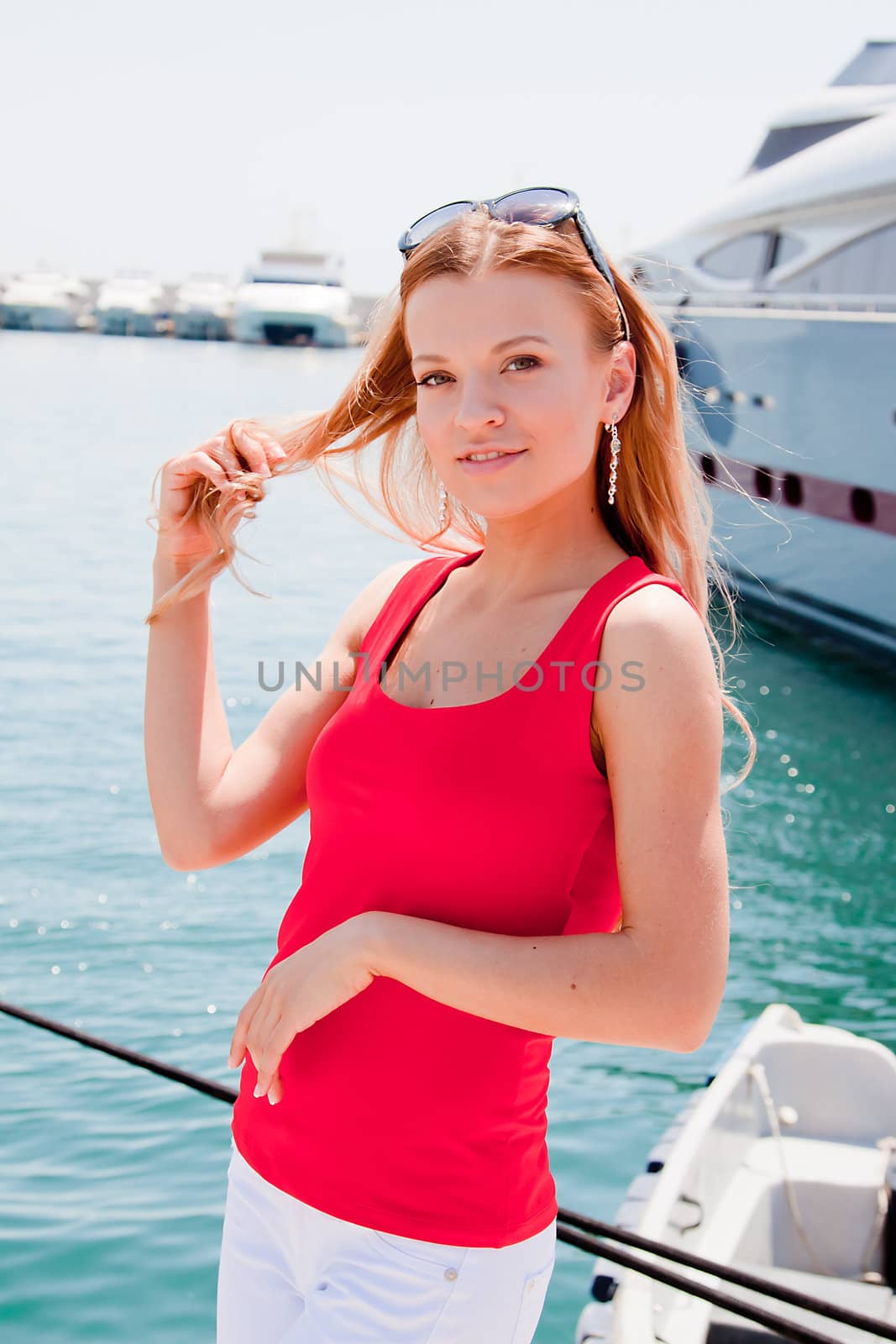 Photo of a young and beautiful girl against the backdrop of yachts in the port