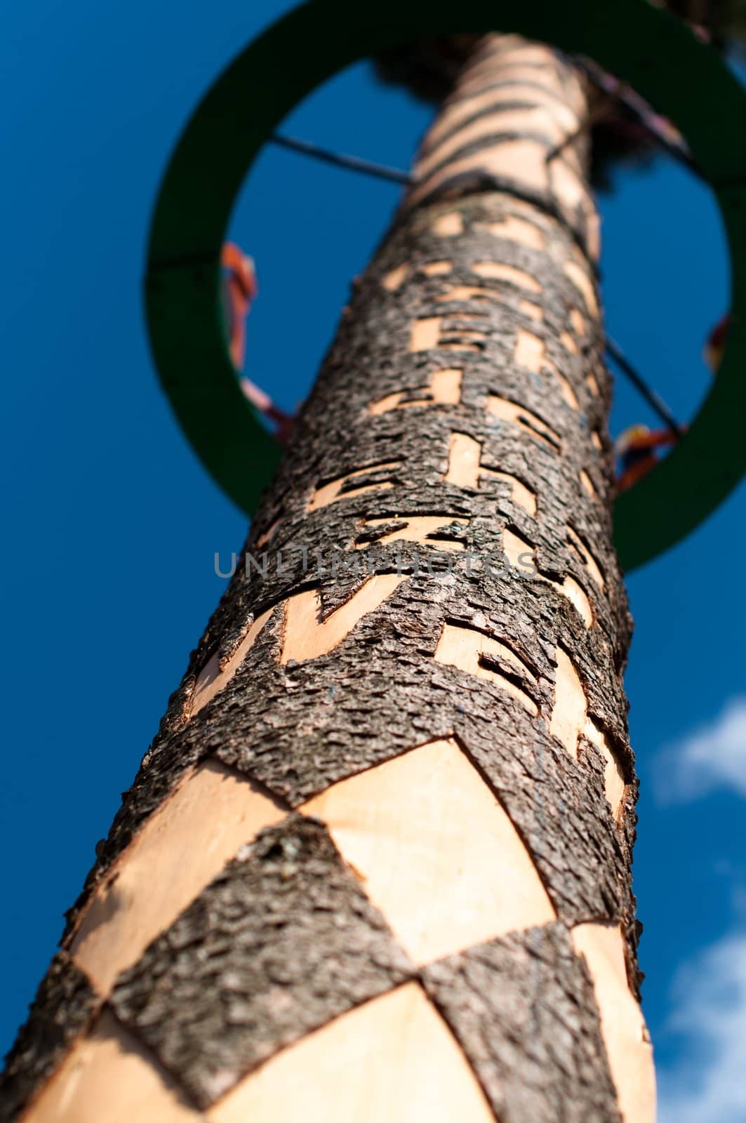 Richly decorated and engraved may pole on sky background