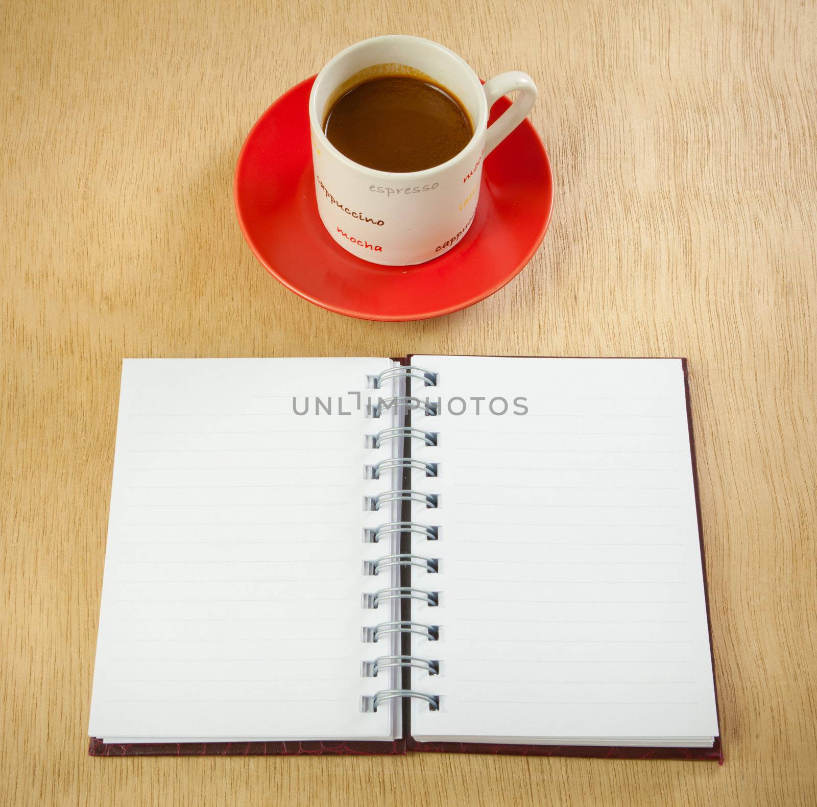 red cup of hot coffee and book on wood background