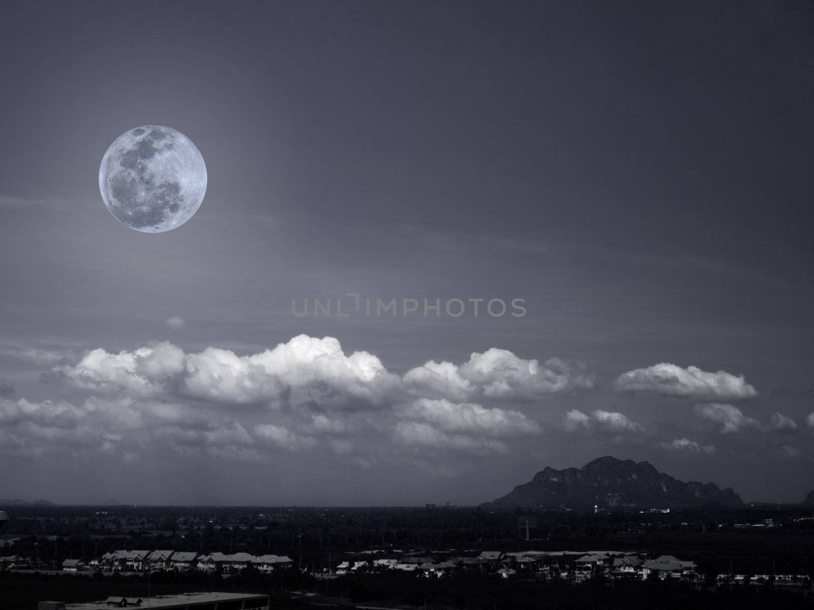 Full moon rises over the mountain and village