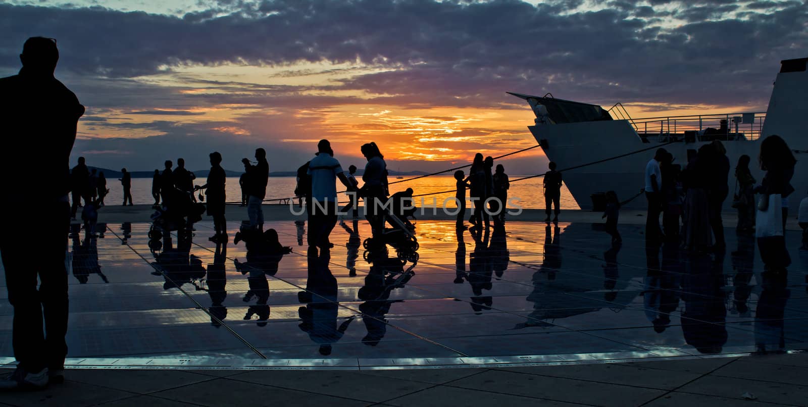 Greetings to the sun installation in Zadar, people silhouette at sunset