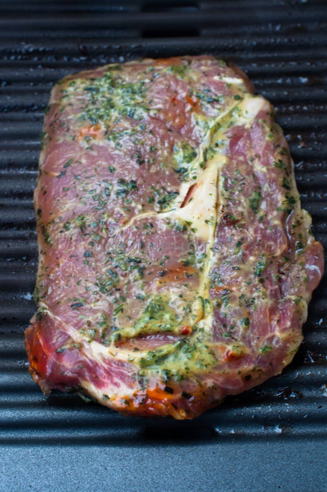 Marinated entrecote steak freshly put on the barbecue
