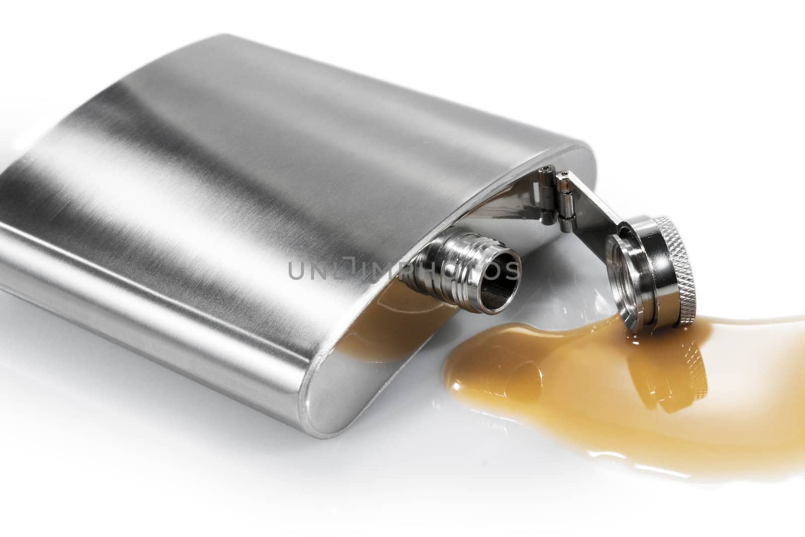 Flask and spilled alcohol on the white background. Isolated.